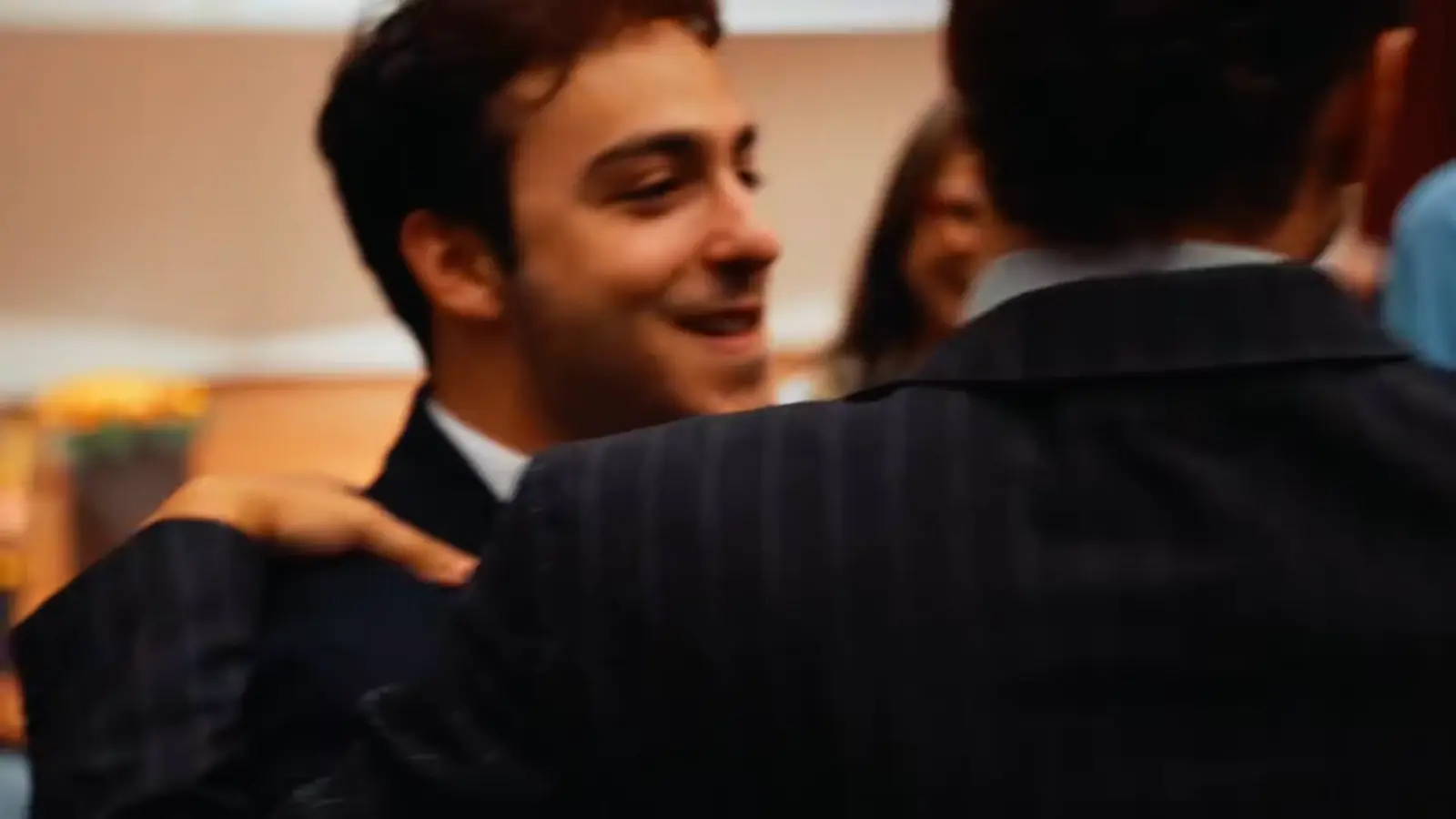 Graduates hugging in the hall after the ceremony.