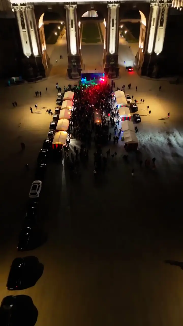 Crowds and stalls under the Cinquantenaire arch at night, at the Charshanbeh Soori fire festival in Brussels.