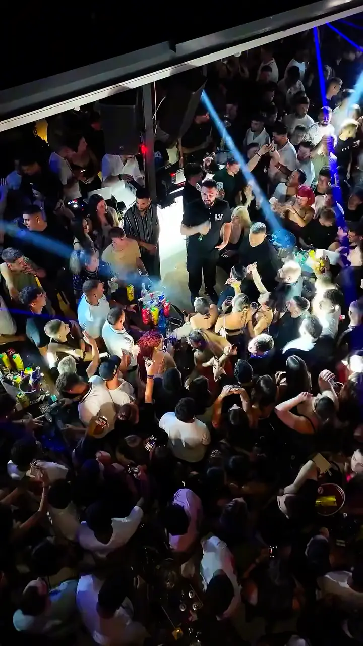 Looking down on the packed crowd at V Lounge Bar during Toquel’s live show, under the stage lights.